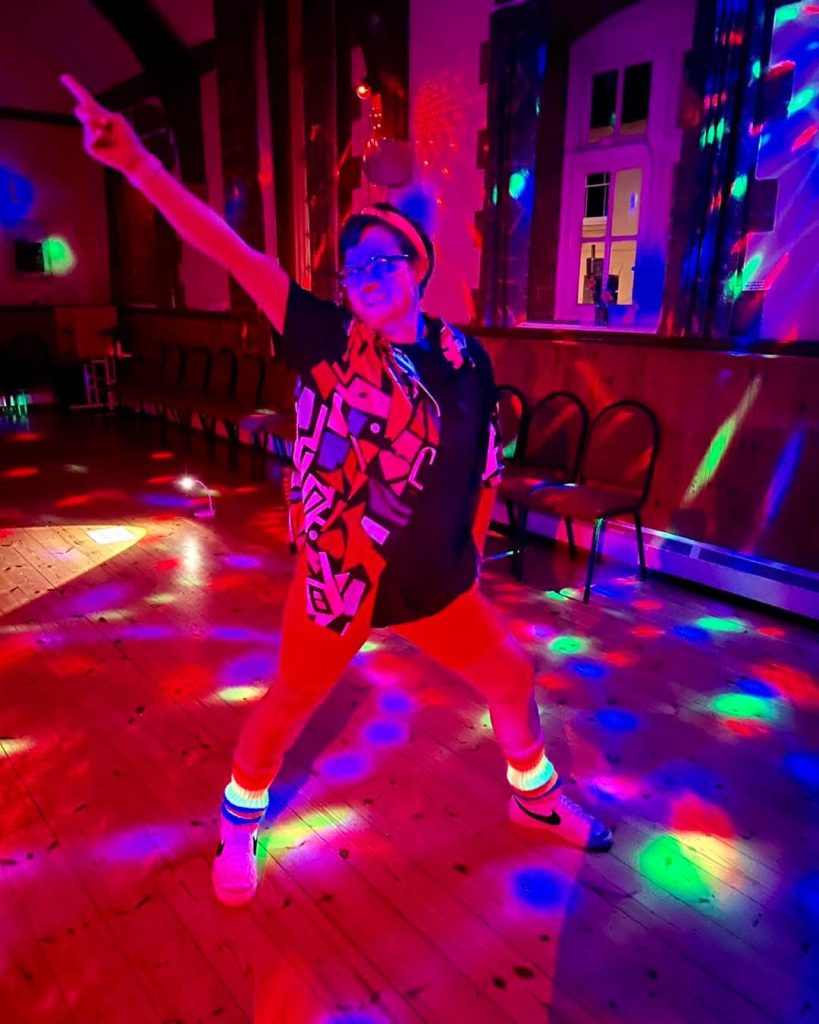 Instructor leading an 80s and 90s disco-inspired HIIT class in Mere, Wiltshire.